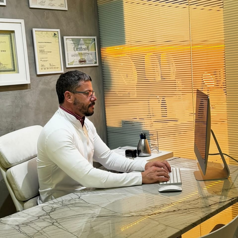 Dr. Fernando Brasil no consultório, planejando um tratamento no computador