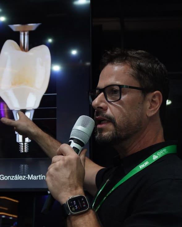 Dr. Fernando Brasil em palestra, apontando a imagem de uma coroa sobre implante no telão